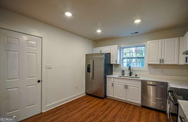 kitchen featuring backsplash, stainless steel appliances, sink, white cabinets, and dark hardwood / wood-style floors