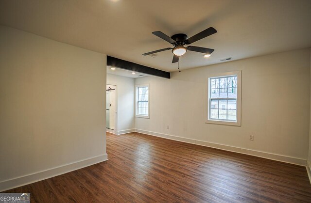 spare room with plenty of natural light, dark wood-type flooring, and ceiling fan