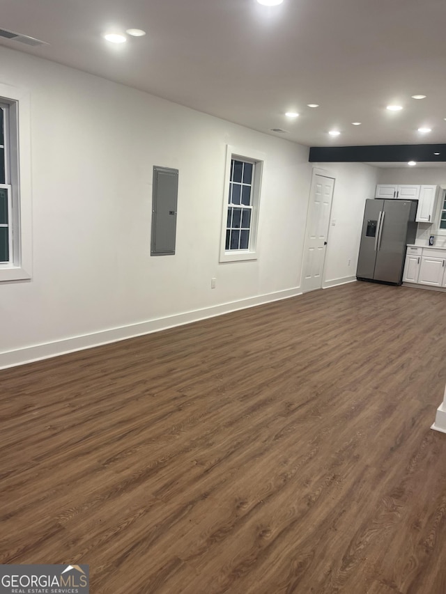 unfurnished living room featuring dark hardwood / wood-style floors and electric panel