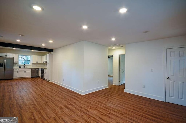 unfurnished living room featuring dark hardwood / wood-style floors and sink