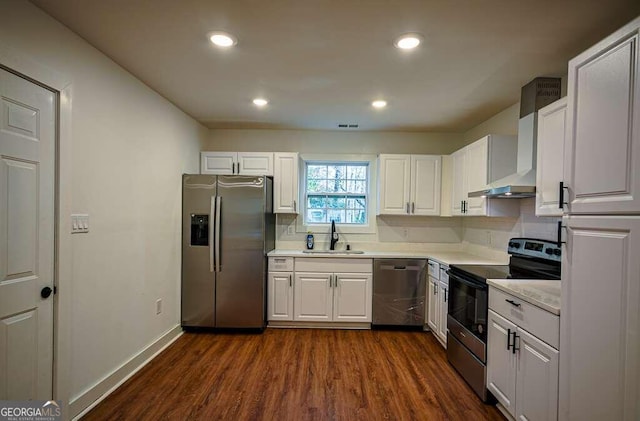 kitchen featuring white cabinetry, sink, wall chimney exhaust hood, dark wood-type flooring, and stainless steel appliances