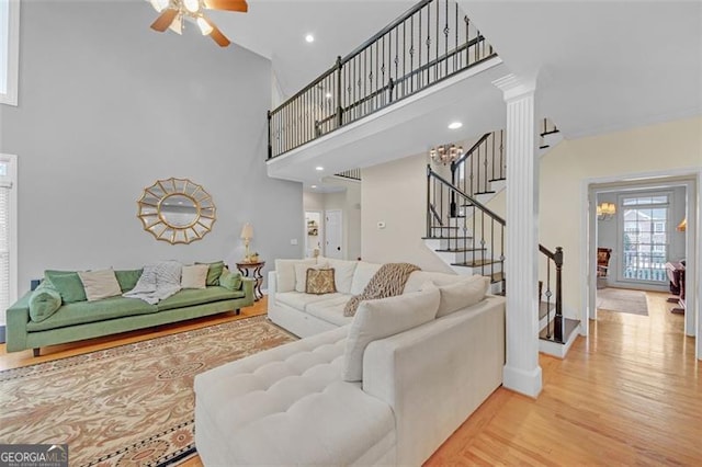 living room with recessed lighting, a towering ceiling, a ceiling fan, wood finished floors, and stairs