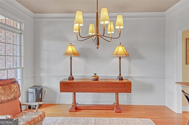 interior space featuring hardwood / wood-style floors, ornamental molding, and a notable chandelier