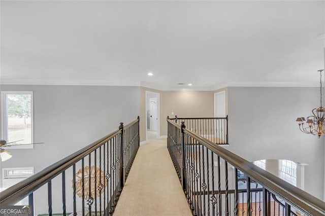 hallway featuring recessed lighting, light colored carpet, an inviting chandelier, ornamental molding, and an upstairs landing