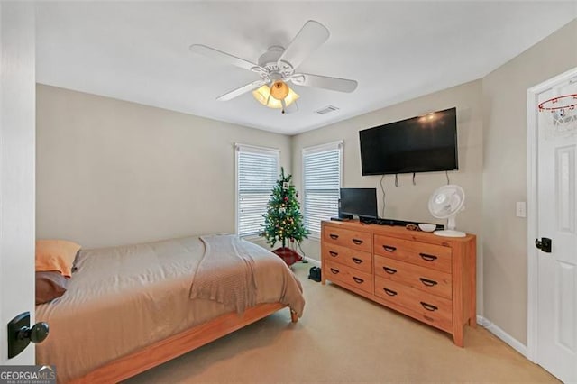 bedroom featuring a ceiling fan, light carpet, visible vents, and baseboards