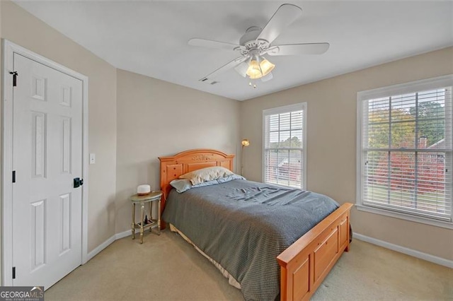 bedroom with light carpet, a ceiling fan, and baseboards