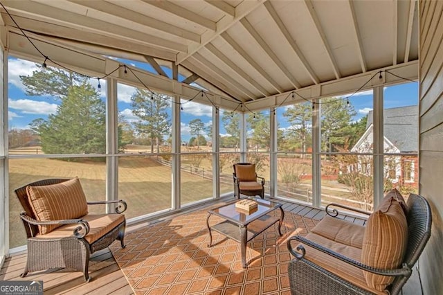 sunroom featuring vaulted ceiling with beams and a wealth of natural light