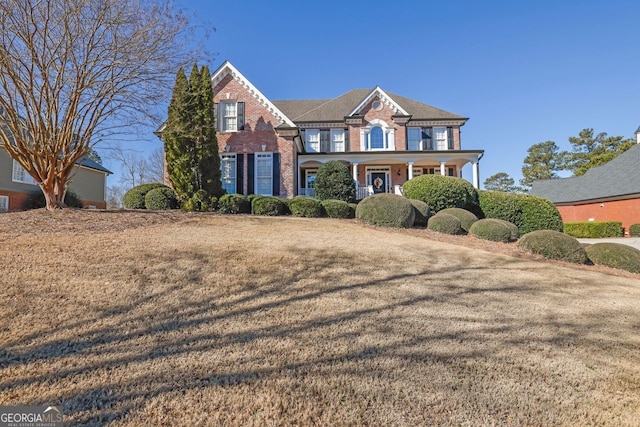 view of front of property with a front yard and brick siding