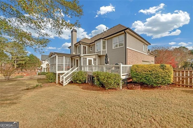 rear view of property with a sunroom and a wooden deck