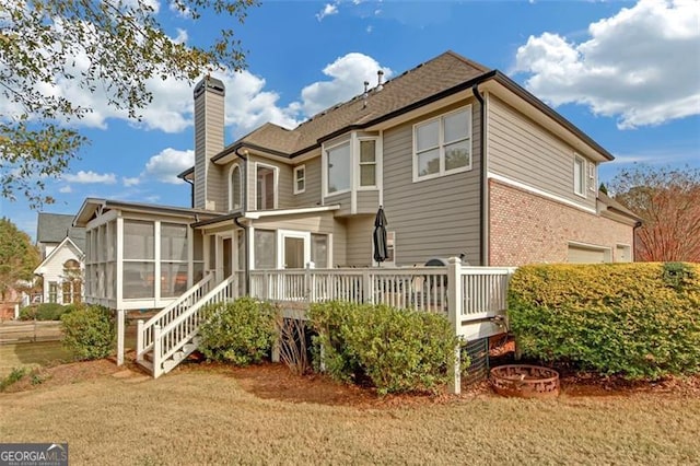 rear view of house featuring a wooden deck and a sunroom