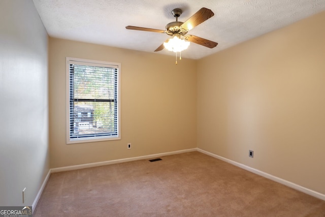 carpeted spare room with ceiling fan and a textured ceiling