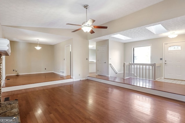 interior space featuring a skylight, a textured ceiling, hardwood / wood-style flooring, and ceiling fan