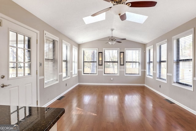 unfurnished sunroom with lofted ceiling with skylight and ceiling fan