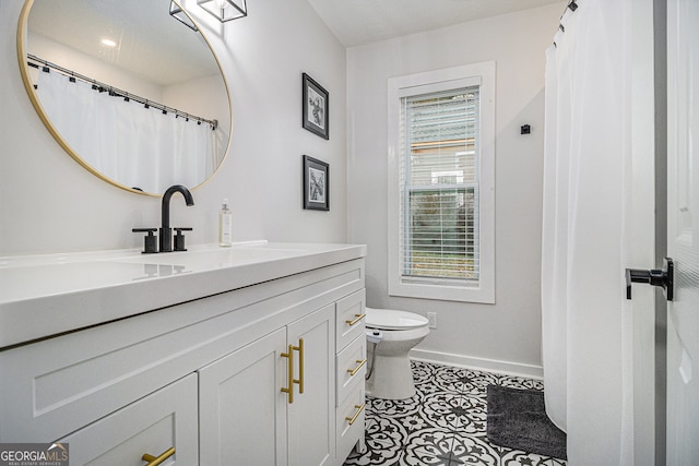 bathroom featuring tile patterned flooring, vanity, and toilet