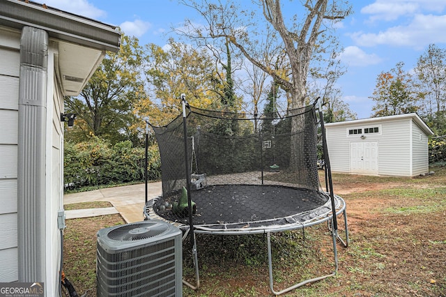 view of yard with a patio, a trampoline, central AC, and a storage shed