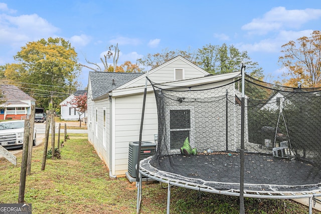 view of property exterior with central AC and a trampoline