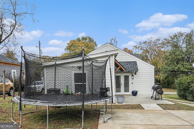 back of house featuring french doors, a patio, and a trampoline