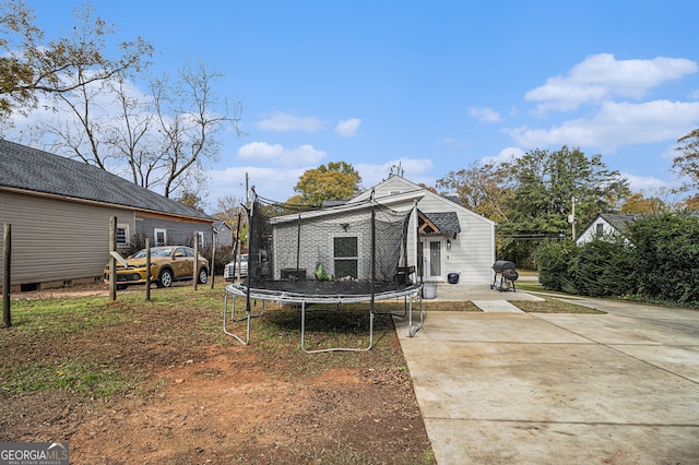 back of property featuring a trampoline