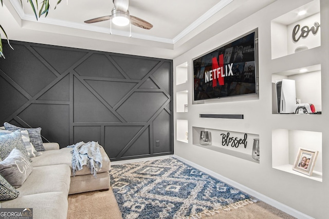 living room with built in shelves, ceiling fan, ornamental molding, and carpet floors