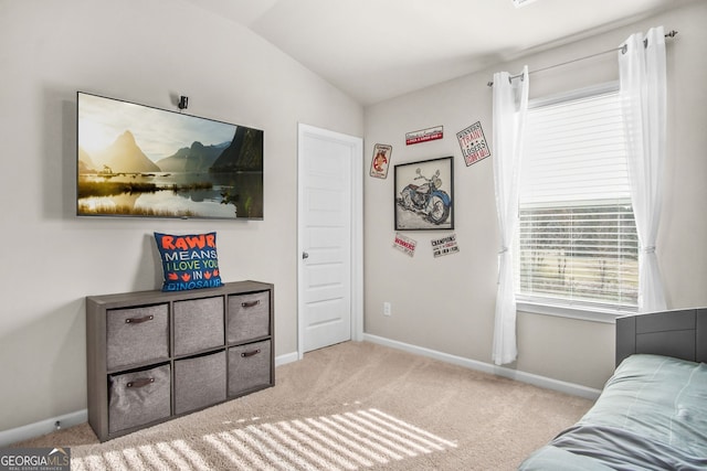 bedroom featuring light colored carpet and vaulted ceiling