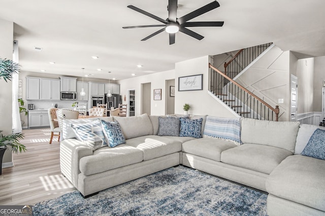 living room featuring ceiling fan and light wood-type flooring