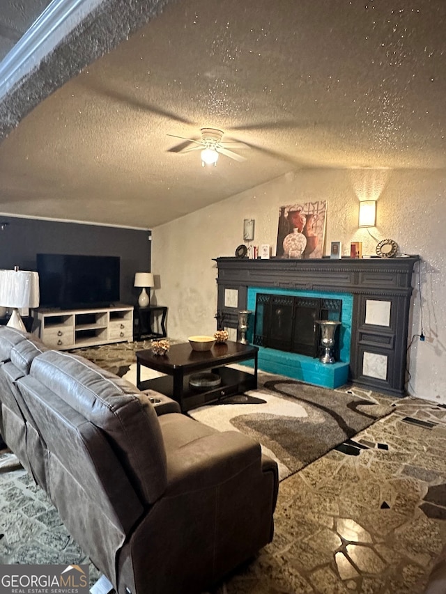 living room featuring ceiling fan, a textured ceiling, and vaulted ceiling