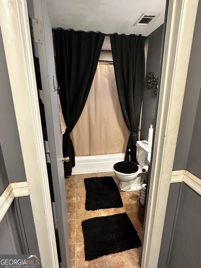 bathroom with shower / tub combo and toilet