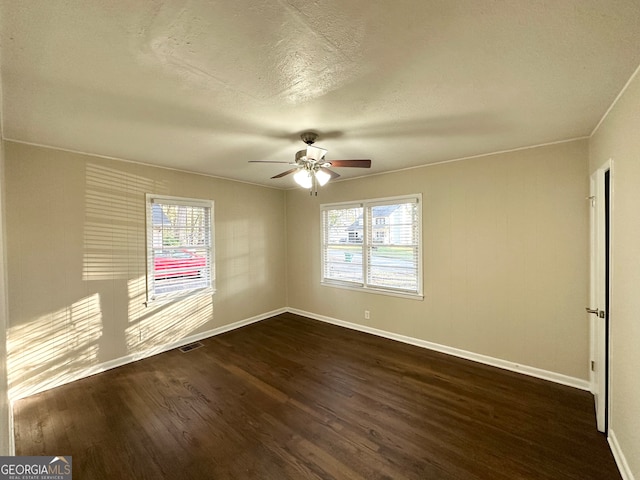 spare room featuring dark hardwood / wood-style flooring, ornamental molding, and a wealth of natural light