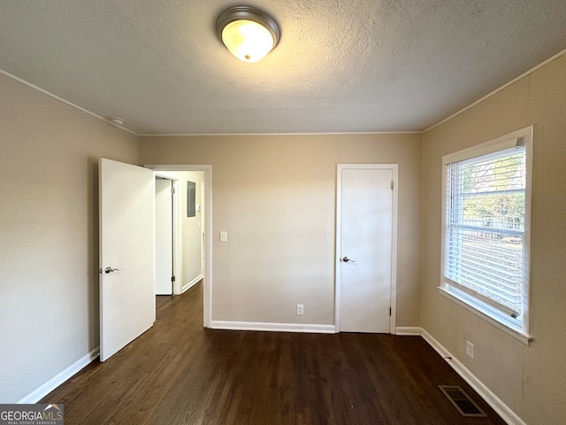 unfurnished bedroom featuring dark hardwood / wood-style floors and a textured ceiling