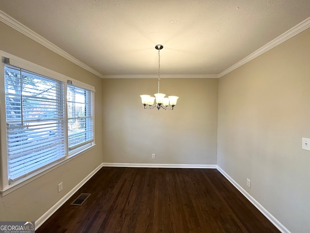 unfurnished dining area with a textured ceiling, dark hardwood / wood-style flooring, crown molding, and an inviting chandelier