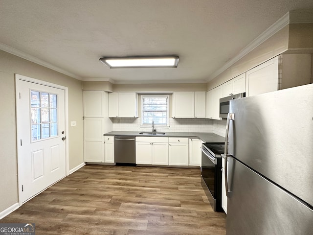 kitchen with white cabinets, wood-type flooring, sink, and appliances with stainless steel finishes