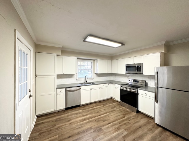 kitchen featuring white cabinets, appliances with stainless steel finishes, hardwood / wood-style flooring, and sink