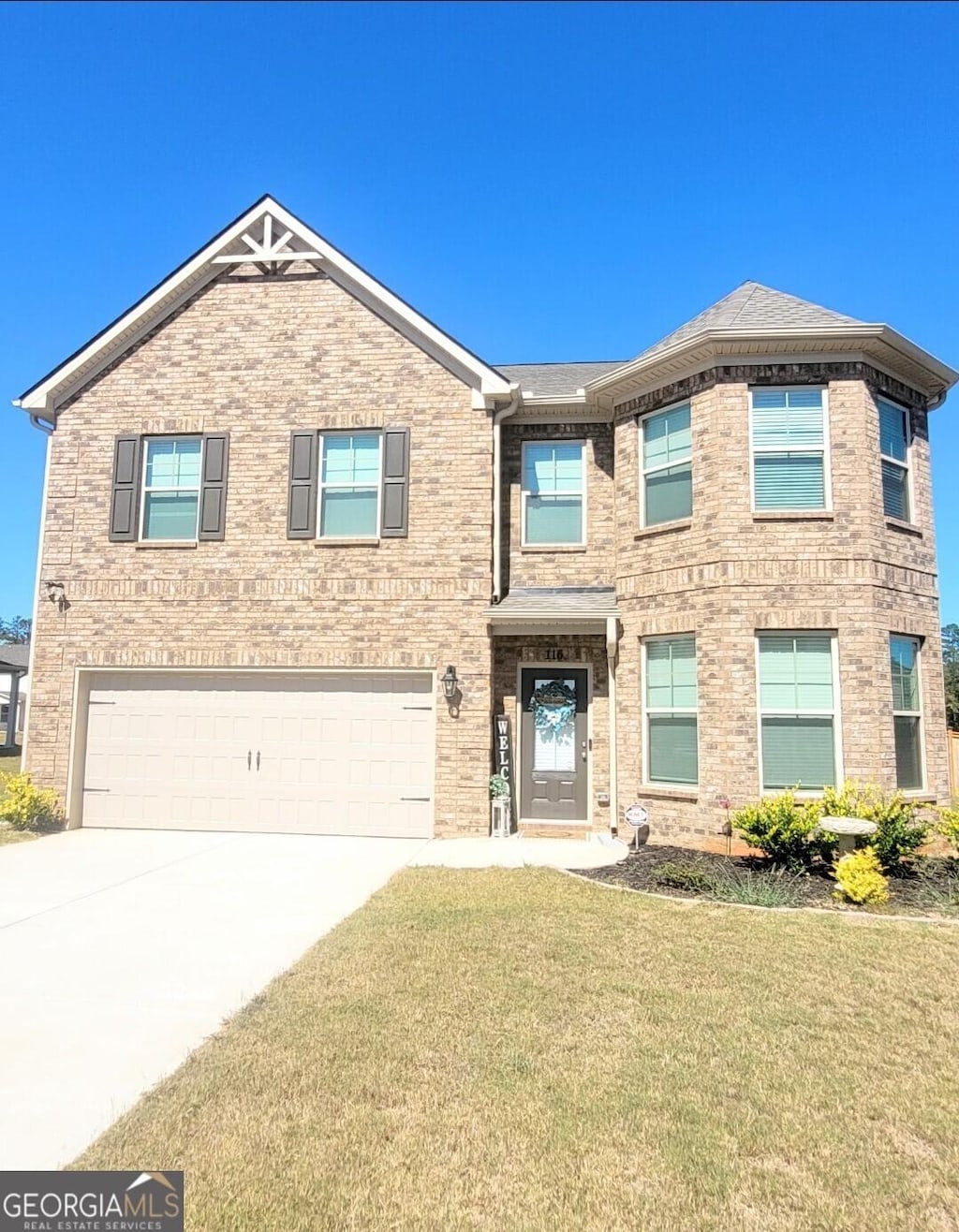 view of front of property featuring a garage and a front lawn