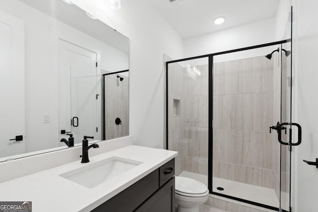 bathroom with toilet, vanity, and walk in shower