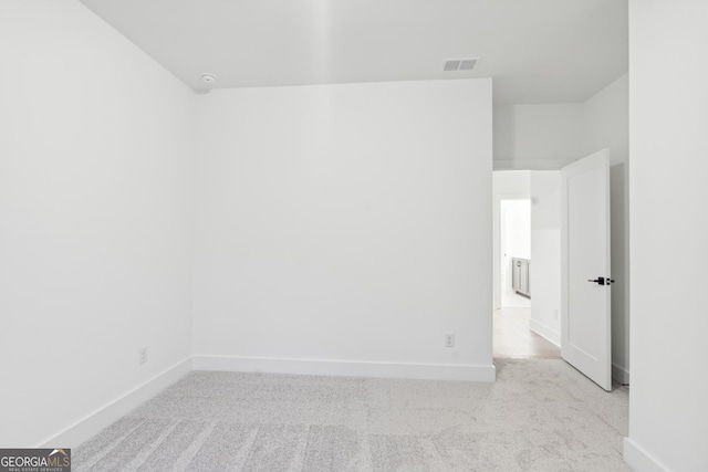 spare room featuring light colored carpet