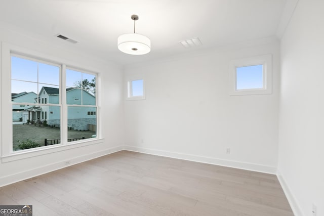 unfurnished room featuring light hardwood / wood-style floors and crown molding