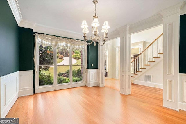 interior space with crown molding, wood-type flooring, and an inviting chandelier