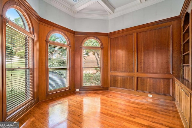 spare room featuring plenty of natural light, light hardwood / wood-style floors, ornamental molding, and coffered ceiling