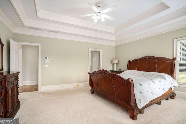 bedroom with a tray ceiling, ceiling fan, ornamental molding, and light colored carpet