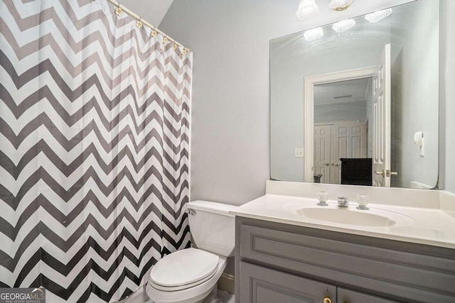 bathroom featuring vanity, toilet, and walk in shower