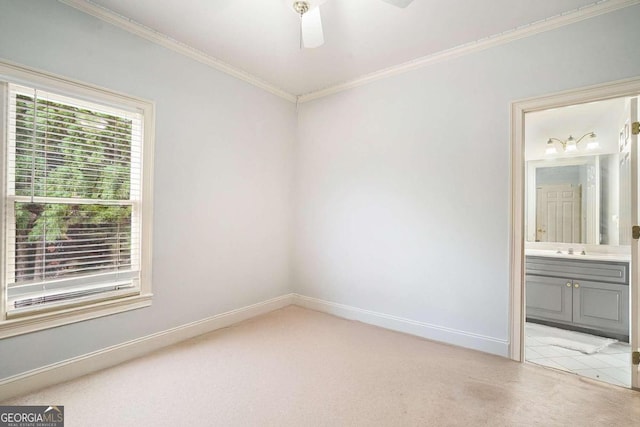 spare room with light carpet, crown molding, ceiling fan, and sink