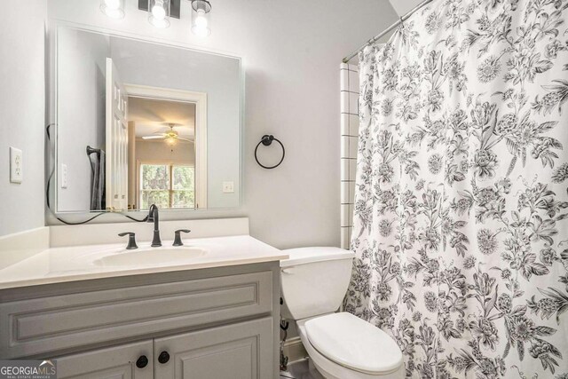 bathroom featuring a shower with curtain, ceiling fan, vanity, and toilet