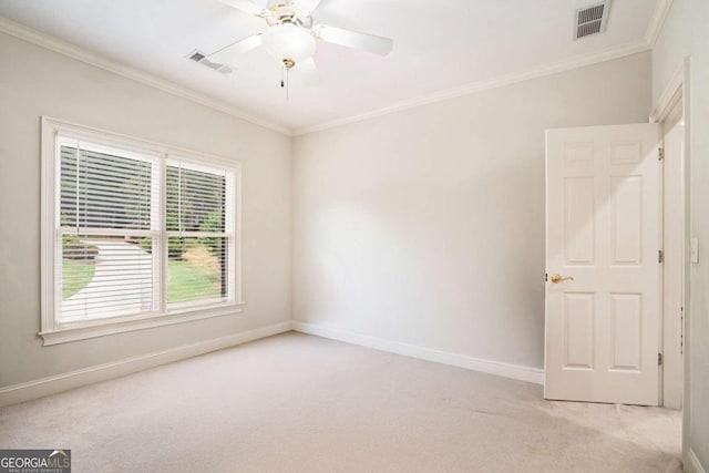 empty room with ceiling fan, light colored carpet, and ornamental molding