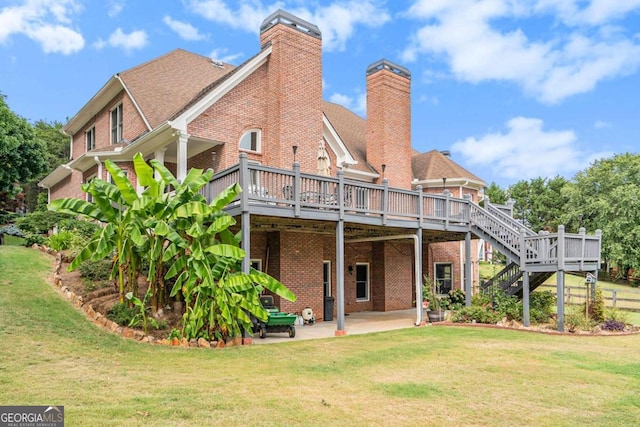 rear view of house with a deck, a patio area, and a lawn