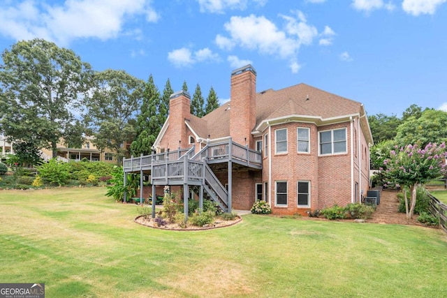 rear view of property with a yard and a wooden deck