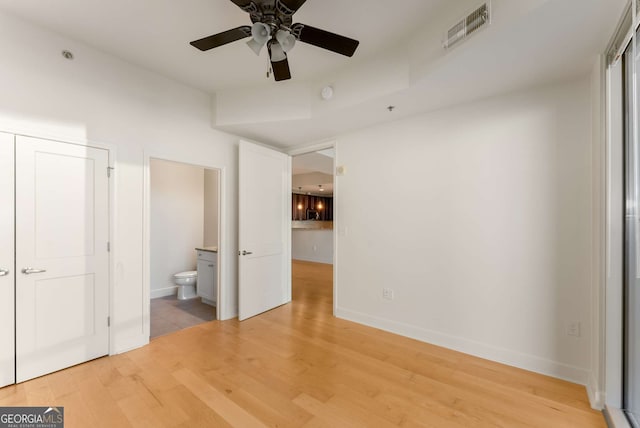 unfurnished bedroom featuring hardwood / wood-style floors and ensuite bath