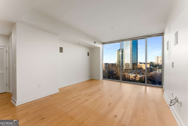 unfurnished living room featuring floor to ceiling windows and light hardwood / wood-style flooring