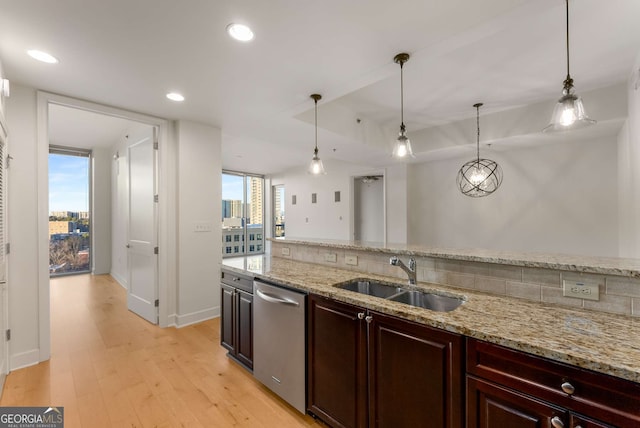 kitchen with light stone counters, sink, pendant lighting, and dishwasher