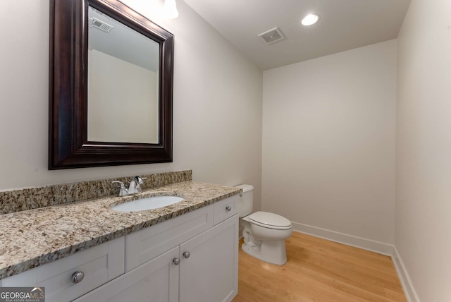 bathroom featuring vanity, hardwood / wood-style floors, and toilet