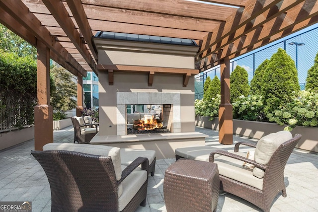 view of patio featuring a tiled fireplace and a pergola